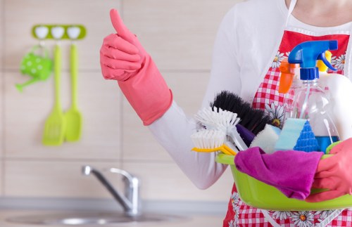 Professional oven cleaner working in an E14 home kitchen