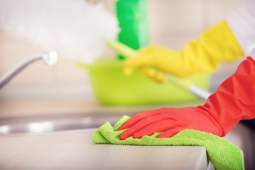 Professional cleaner dusting and tidying a local home in E14